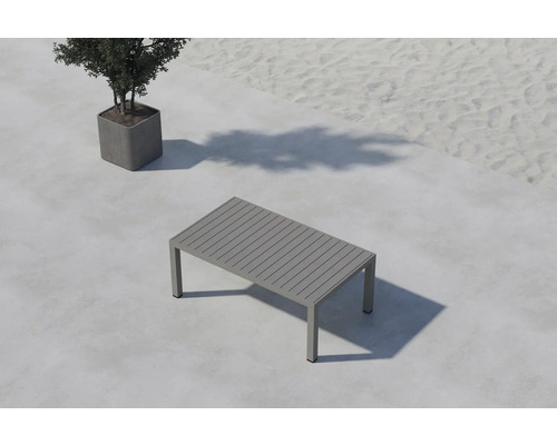 Rektangulärt trädgårdsbord i aluminium med ribbad bordsskiva bredvid en krukväxt