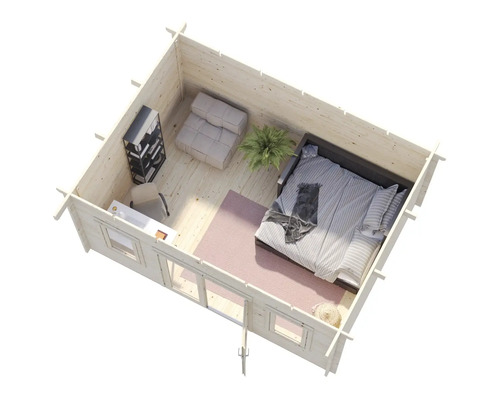 Interiörbild av ett trähus med säng, fåtölj, skrivbord och hyllor