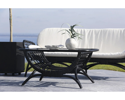 Trädgårdsscen med soffbord i rotting, vas och dekorativ skål