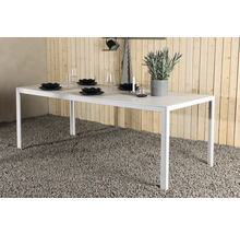 Dukat vitt trädgårdsbord med dekoration och porslin.