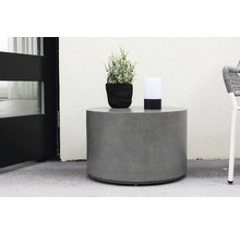 Runt betongbord med växt och lampa