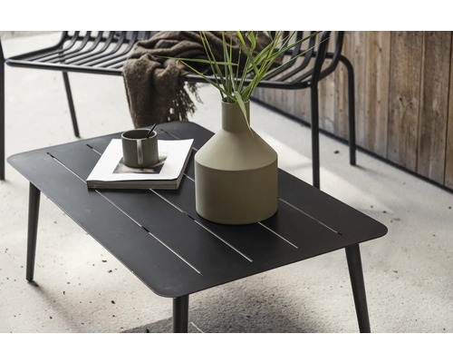 Svart loungebord i metall med dekoration utomhus