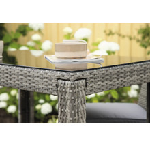 Detaljvy av ett trädgårdsbord med glasskiva och rottingstruktur