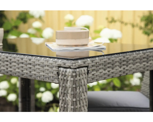 Detaljvy av ett trädgårdsbord med glasskiva och rottingstruktur