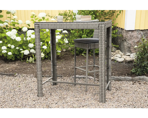 Högt rottingbord med barstol för utomhusbruk på grus