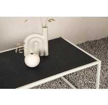 Dekorativt arrangemang på ett svart sidobord med metallram