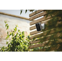 Övervakningskamera på ett trästaket utomhus