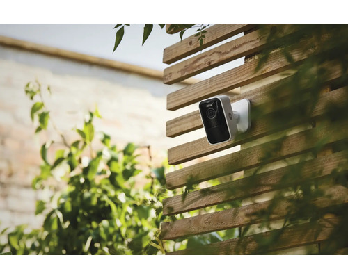 Övervakningskamera på ett trästaket utomhus