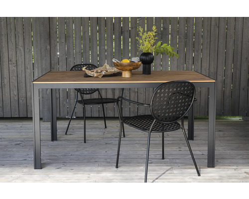 Matbord med två stolar utomhus, dekorerat med frukt och blommor