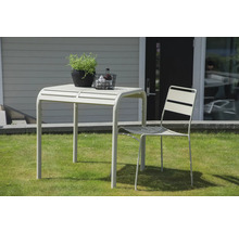 Trädgårdsscen med bord, stol och dekoration utomhus.