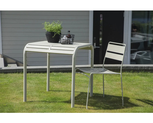 Trädgårdsscen med bord, stol och dekoration utomhus.