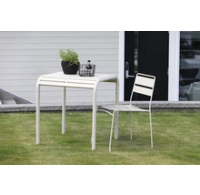 Trädgårdsscen med trädgårdsbord och trädgårdsstol på gräsmatta