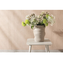 Blomsterarrangemang i räfflad vas på litet bord