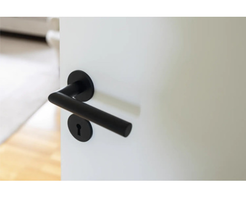 Svart dörrhandtag på en vit dörr