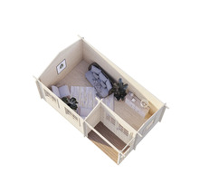 Interiör av ett trähus med möbler som simulerar ett vardagsrum och ett sovrum.