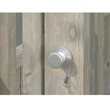 Detaljvy av en silverfärgad dörrknopp på en trädörr