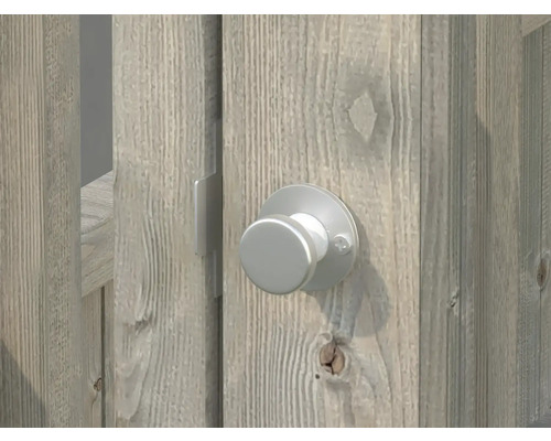 Detaljvy av en silverfärgad dörrknopp på en trädörr