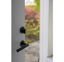 Öppen dörr med svart dörrhandtag och lås