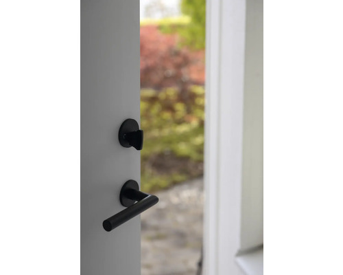 Öppen dörr med svart dörrhandtag och lås