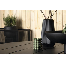 Dekorativ scen med ett grönt bubbel-ljus, en vas och en skål på ett bord