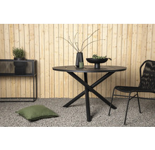 Trädgårdsscen med runt bord, stol, dekoration och växter framför en trävägg