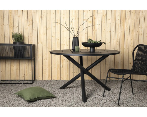 Trädgårdsscen med runt bord, stol, dekoration och växter framför en trävägg