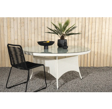 Trädgårdsscen med runt glasbord, rottingstol och dekorativa tillbehör för utomhusbruk