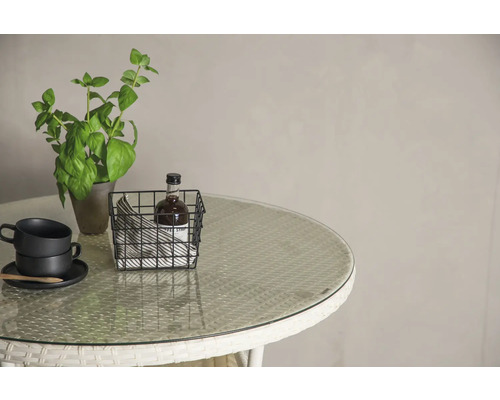 Bordscen med växt, koppar och korg på en rund bordsskiva