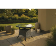 Trädgårdsbord med glasskiva och rottingstruktur på en terrass