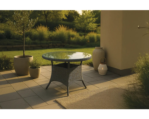 Trädgårdsbord med glasskiva och rottingstruktur på en terrass