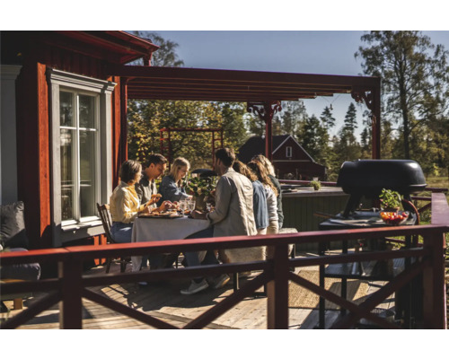 En grupp människor njuter av en utomhusmåltid på en träterrass med en grill.