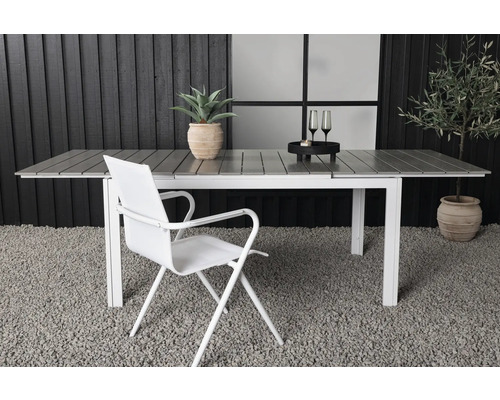 Utsikt med ett förlängningsbart trädgårdsbord, en stol, krukväxter och dekorationer för utomhusbruk