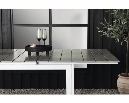 Trädgårdsbord med grå bordsskiva, vit ram, dekoration och växt