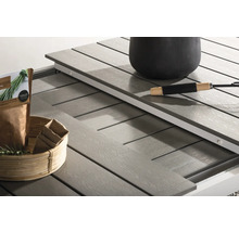 Detaljvy av ett trädgårdsbord med utdragbar design, blomkruka, trädgårdssax och dekoration