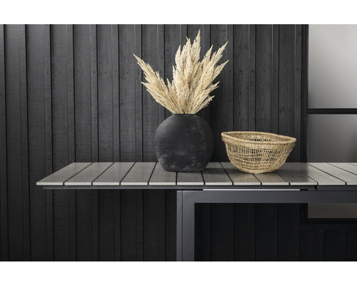 Dekorativ scen med torkade blommor i en vas och en korg på ett trädgårdsbord