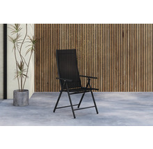 Svart trädgårdsstol framför en trävägg