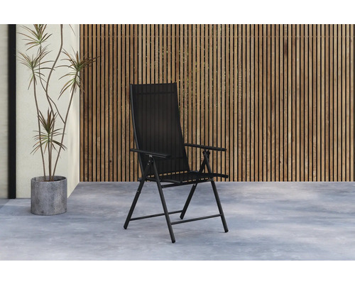 Svart trädgårdsstol framför en trävägg