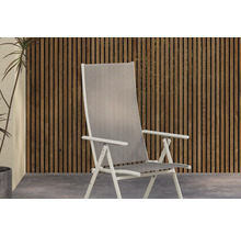 Trädgårdsstol med högt ryggstöd framför trävägg