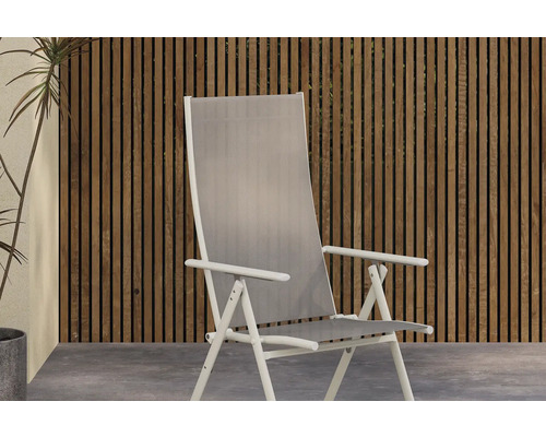 Trädgårdsstol med högt ryggstöd framför trävägg