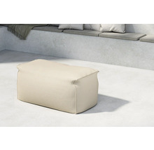 Beige sittpuff av tyg i en interiör