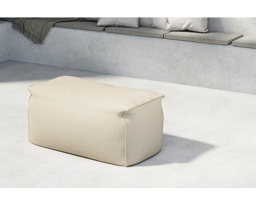 Beige sittpuff av tyg i en interiör