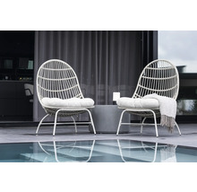 Två rottingfåtöljer med kuddar och ett sidobord på en terrass intill en pool