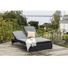 Dubbel solstol av polyrotting med grå dynor, kudde, filt och solglasögon på en träaltan