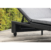 Detaljvy av en trädgårdsliggstol i rotting med hjul.