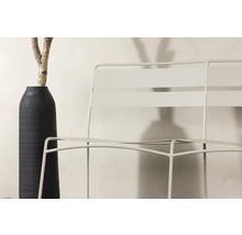 Trädgårdsscen med metallstol och dekorativ vas