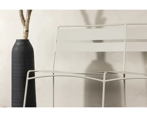 Trädgårdsscen med metallstol och dekorativ vas