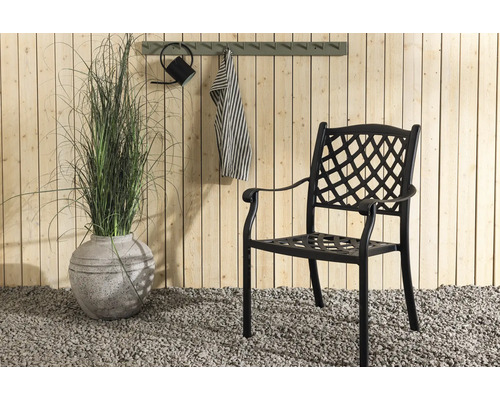 Trädgårdsscen med stol, dekoration och växter