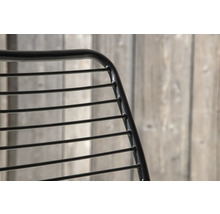 Detaljvy av en stol med metallram och horisontella ribbor