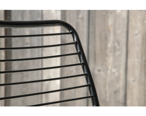 Detaljvy av en stol med metallram och horisontella ribbor