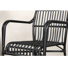 Närbild av en svart rottingfåtölj.